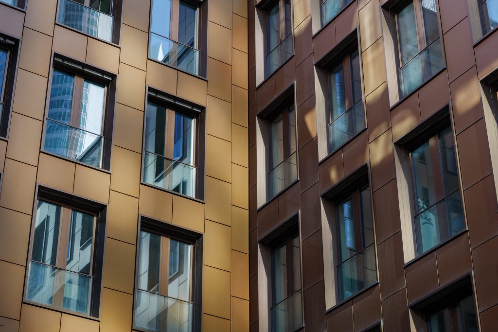 Exterior architectural detail modern golden facade of High-rise office buildings. Abstract Urban metropolis background.